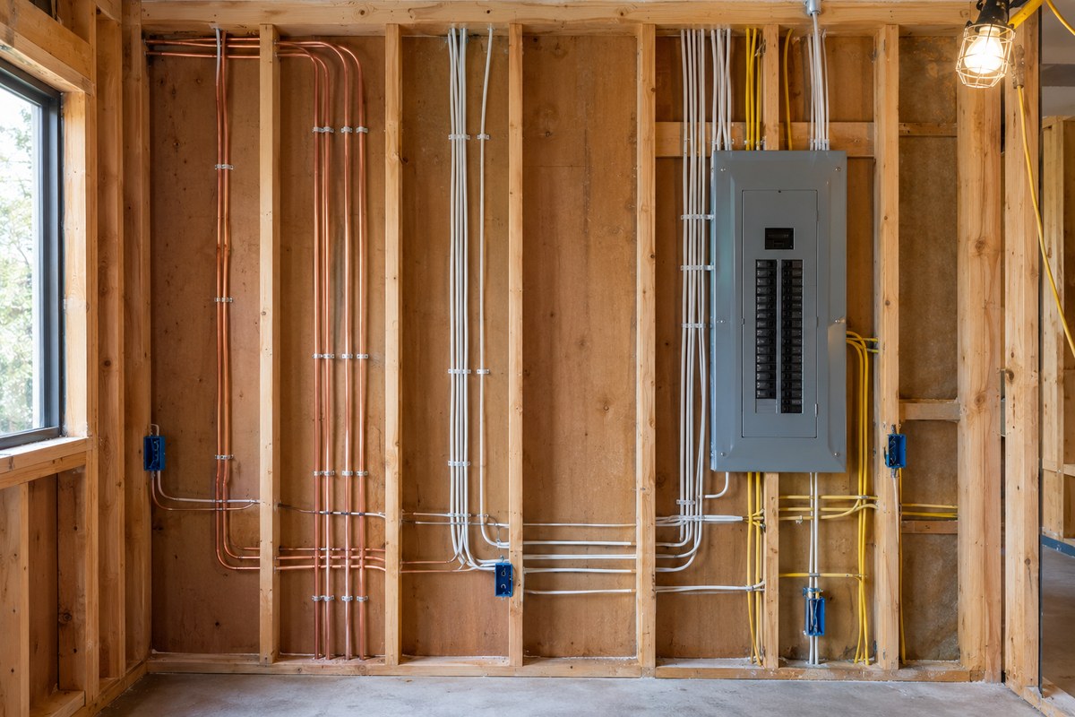 Illustrative image: new electrical wiring and a panel in an open framed wall